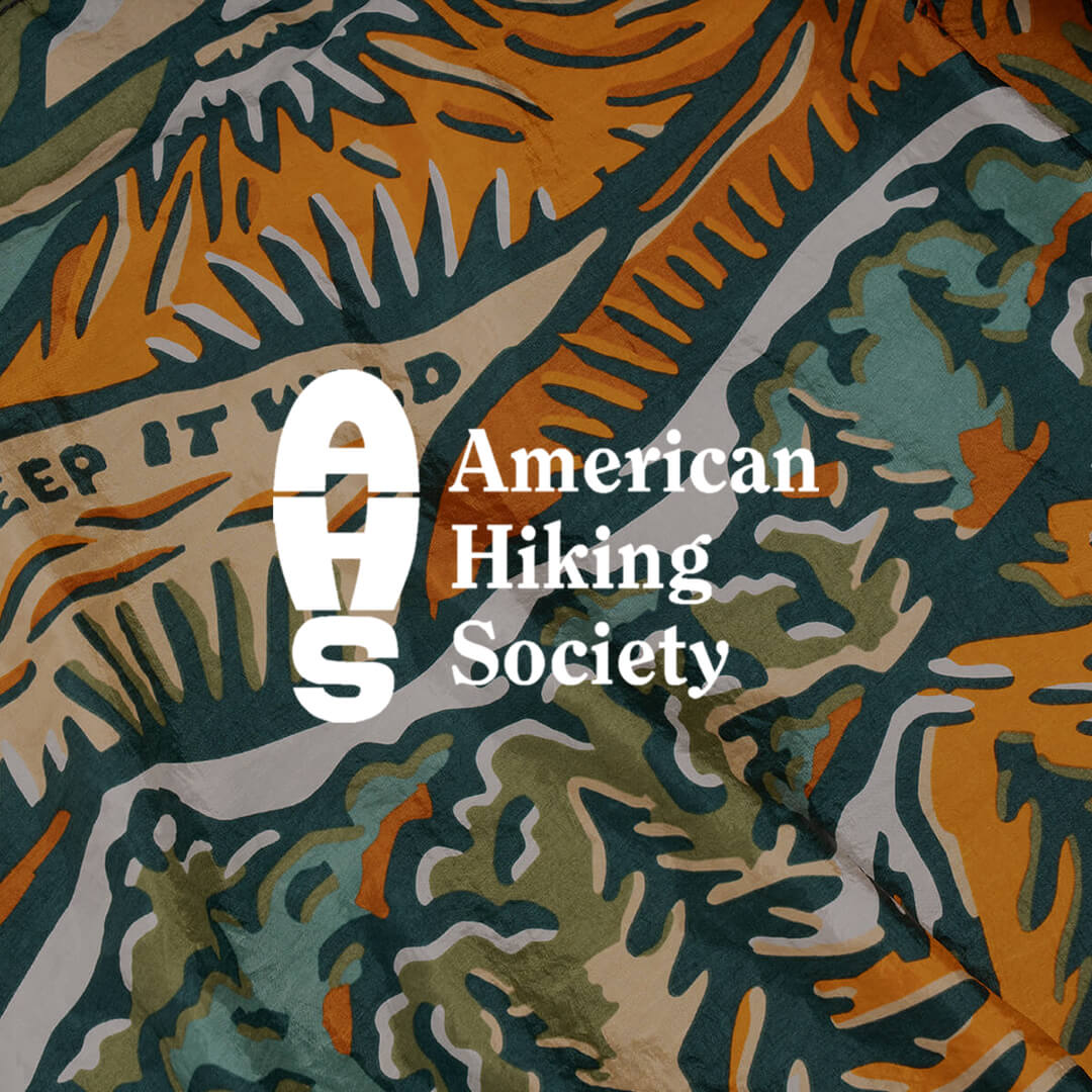 American Hiking Society logo on a nature-themed fabric background