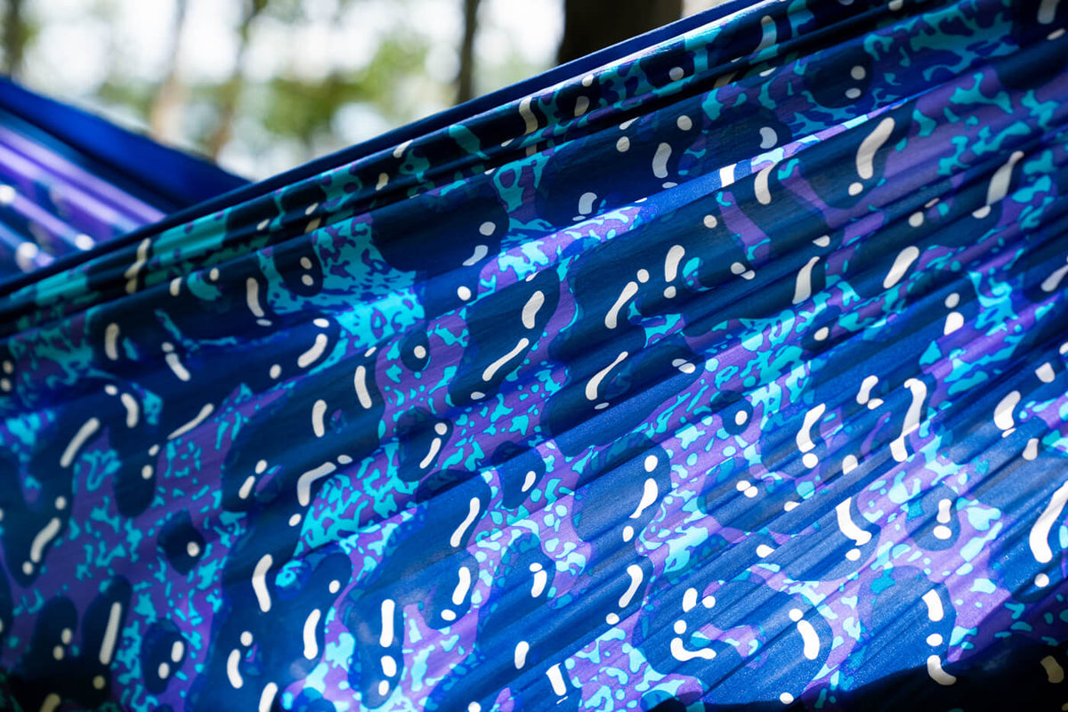 A close up detail shows the ENO Splash DoubleNest Hammock Print by ENO. The print is a mix of blue, purple and while blobs.