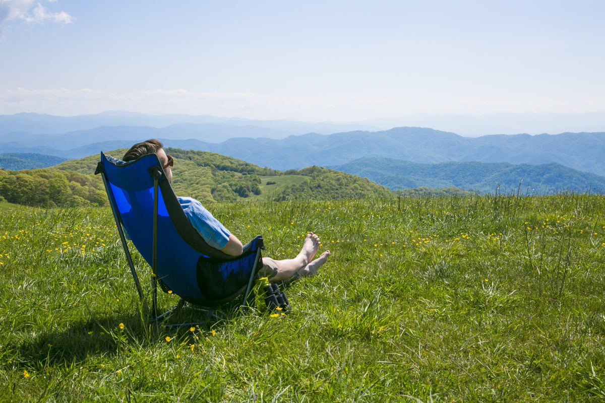 A man sitting in an ENO Lounger DL Chair looking at mountain ranges