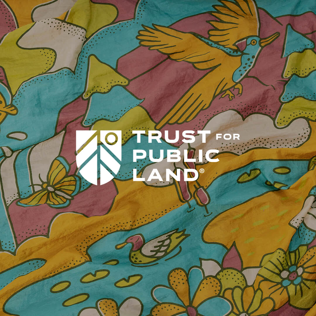 Colorful fabric with nature-themed design featuring birds, butterflies, and flowers, with Trust for Public Land logo overlay.