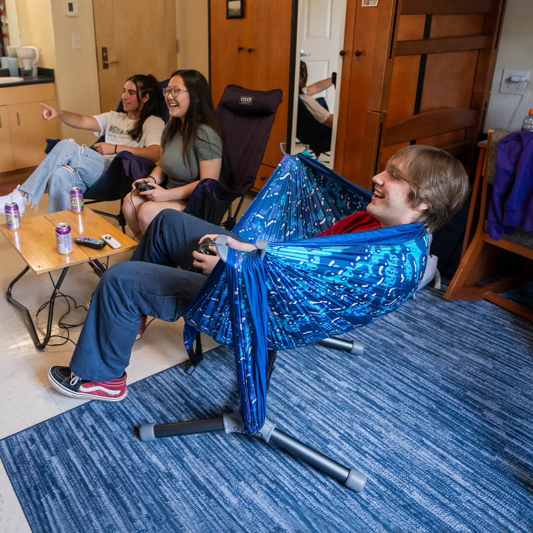 Person using the ENO Parklite Hammock Chair Stand with DoubleNest Hammock Print in a dorm room environment 